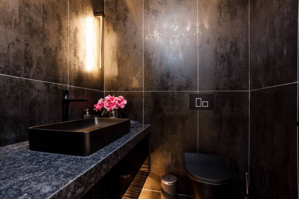 toilet and bathroom sink with black wall in richmond hill