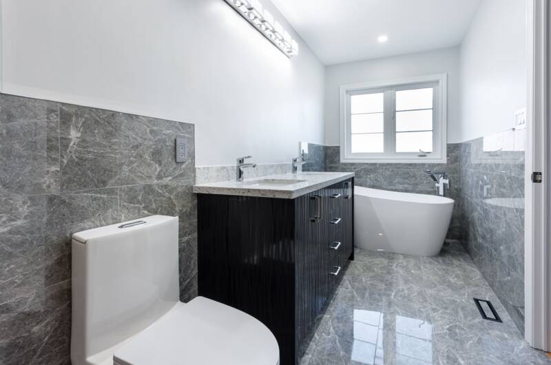 bathroom renovation in toronto - marble tiling and countertop with a modern vanity and bathtub